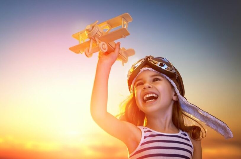 Un bambino con un aereo giocattolo per simboleggiare i viaggi e i consigli per viaggiare da solo Un bambino con un aereo giocattolo per simboleggiare i viaggi e i consigli per viaggiare da solo