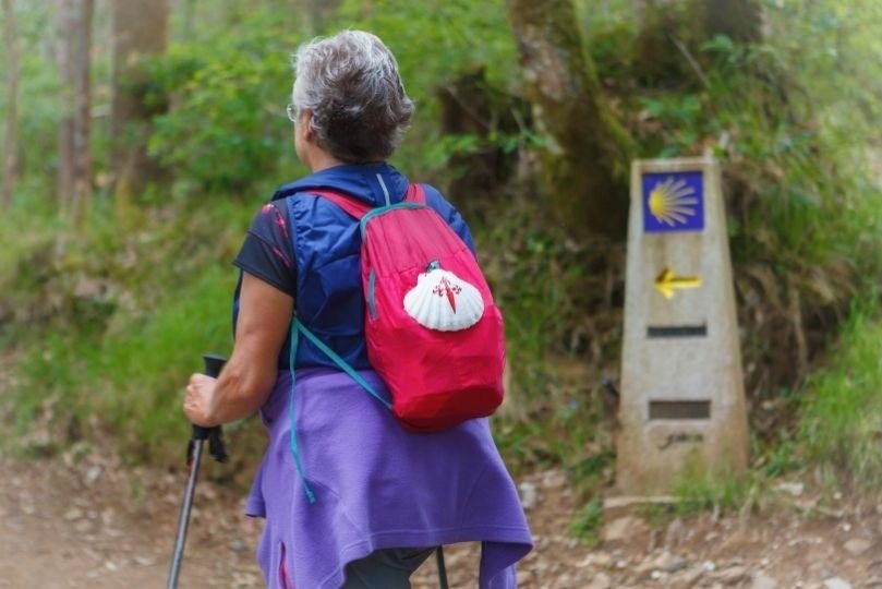 Cammino di Santiago eta per una pellegrina che cammina con lo zaino Cammino di Santiago eta per una pellegrina che cammina con lo zaino